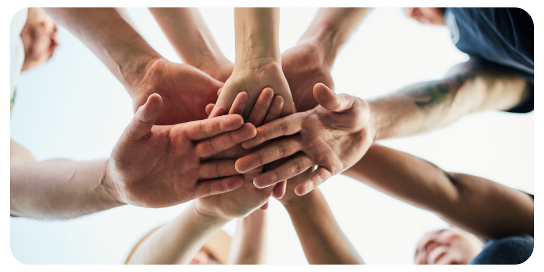 Equipe engajada com mãos sobrepostas, simbolizando parceria, comprometimento e espírito colaborativo nos serviços de BPO Financeiro e Consultoria Empresarial.